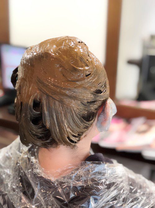 美容院で濃茶のヘアカラーを施すエレガントなアップヘアの様子
