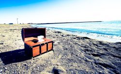 穏やかなビーチと開いた宝箱、冒険の物語を感じさせる風景。