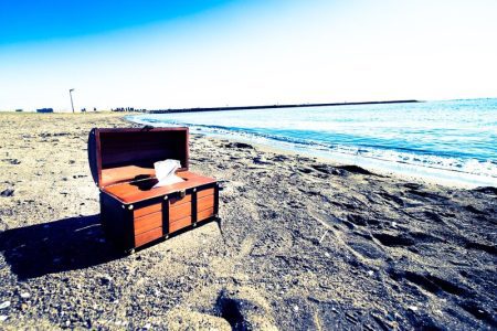 穏やかなビーチと開いた宝箱、冒険の物語を感じさせる風景。